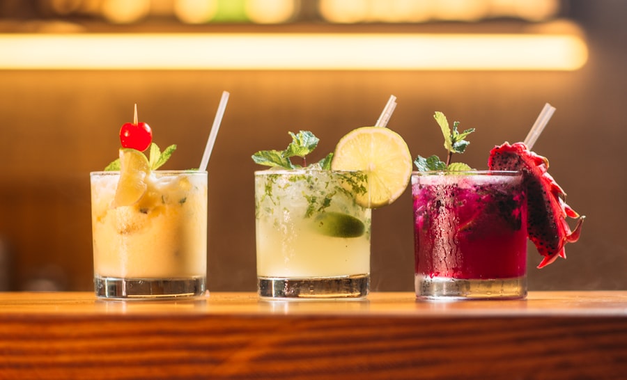 Three colorful cocktails lined up on a bar