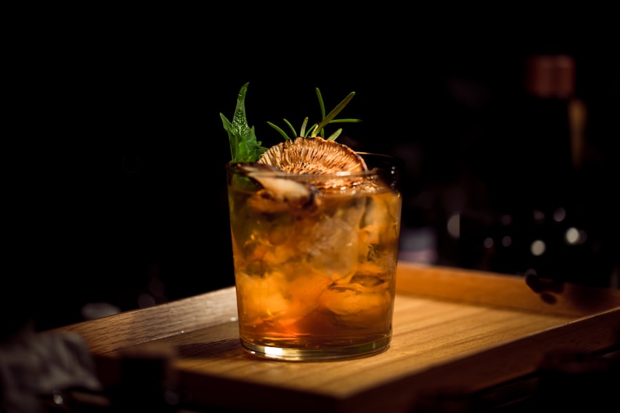 Old fashioned cocktail with rosemary garnish on wood