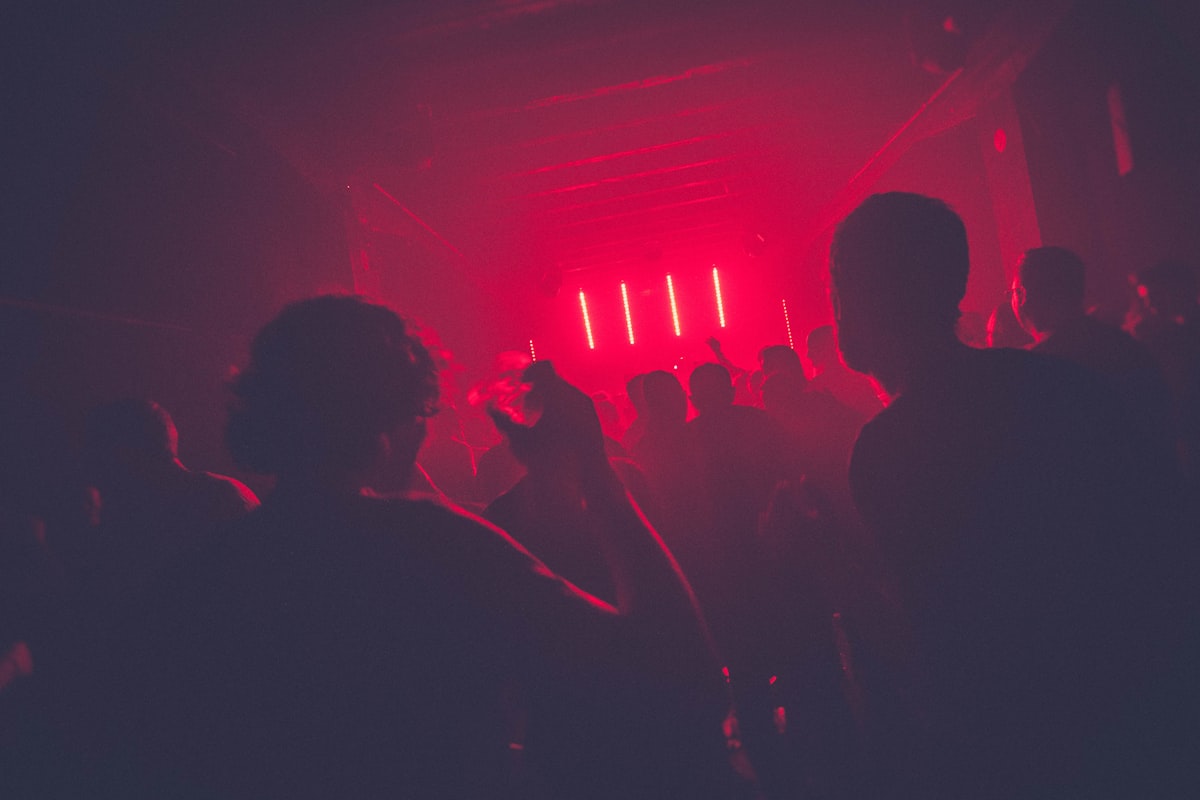 Crowd silhouetted under red stage lights